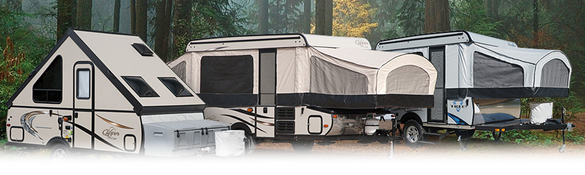 Three Coachmen RV pop-up campers parked at a forest camp site